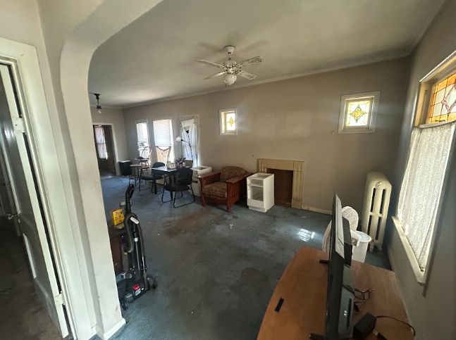 Living room with original fireplace mantel and stained glass window